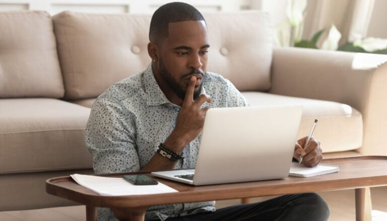 young man determining when to cancel life insurance policy on his laptop