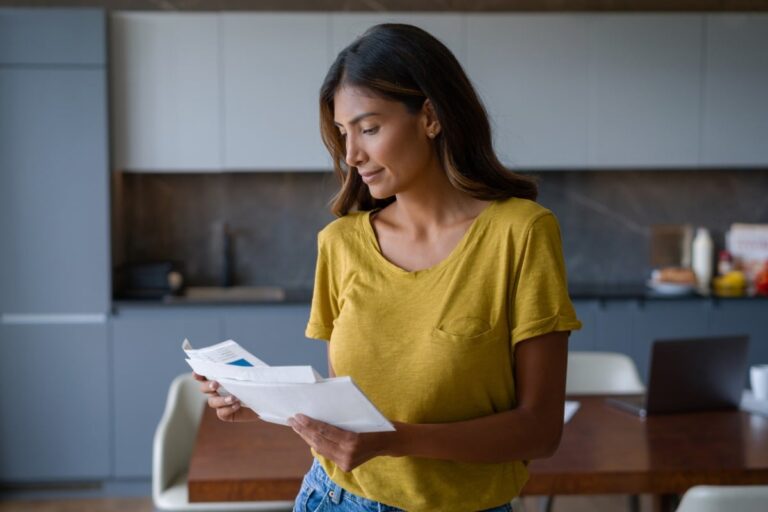 Adult woman in the kitchen reviewing life insurance plans