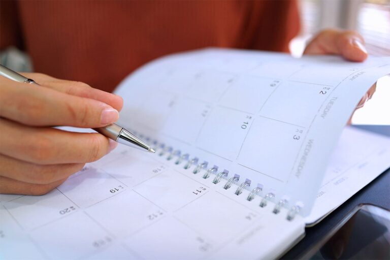 Person writing their life insurance maturity date in a calendar